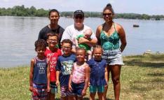 Jenni Benson with smiling group of children next to lake