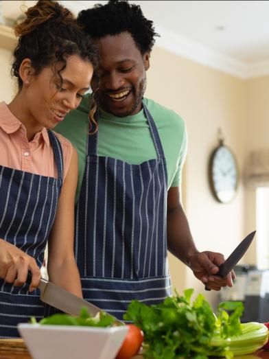 Happy African American couple prepping food in kitchen